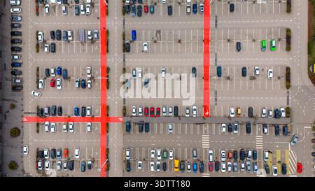 Vue aérienne d'un vaste parking rempli de voitures colorées, les allées peintes en rouge coupant à travers l'asphalte gris, Sremska Mitrovica, Voïvodine, Banque D'Images