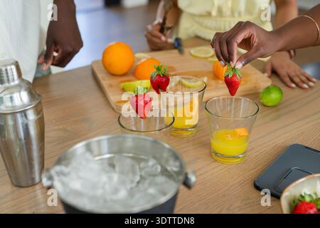 Trois verres de jus d'orange sont garnis de fraises sur un comptoir en bois Banque D'Images