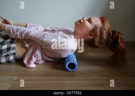 Athlète se reposant sur le rouleau de massage après la récupération d'entraînement et le soulagement de la douleur Banque D'Images