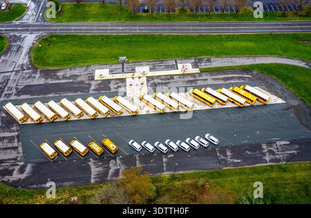 Vue aérienne d'autobus scolaires alignés dans un parking à côté d'une route, une symphonie de jaune contre l'asphalte silencieux, Hopewell Township, New Jersey, U. Banque D'Images