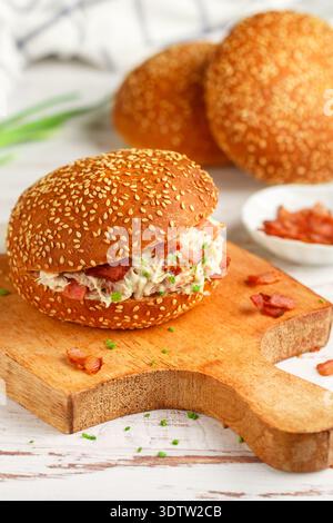 Délicieux sandwich pain au sésame avec salade de poulet, bacon frit, oignons verts, fromage avec sauce ranch. Déjeuner ou dîner pour les gourmets. Mise au point sélective Banque D'Images