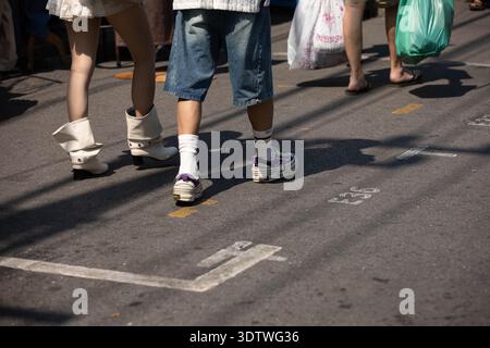 BANGKOK, THAÏLANDE-Jan 28, 2026 : touristes hommes et femmes portant des chaussures de mode marchant dans le marché, vue en angle élevé Banque D'Images