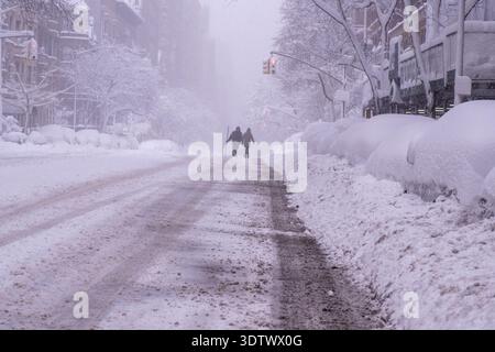 New York, New York, États-Unis. 23 février 2026. Les New-Yorkais et ceux de la région environnante des Tri-State sont frappés par un blizzard historique qui affecte la région des Tri-State. Plus de 15 pouces ont été signalés dans Central Park et jusqu'à 28 pouces dans les zones en dehors de la ville. Les écoles sont fermées et une interdiction de voyager est en vigueur en raison de la tempête qui a créé des conditions de quasi-blancheur. Deux personnes traversent une avenue enneigée du West End. (Crédit image : © Syndi Pilar/ZUMA Press Wire) USAGE ÉDITORIAL SEULEMENT ! Non destiné à UN USAGE commercial ! Crédit : ZUMA Press, Inc/Alamy Live News Banque D'Images