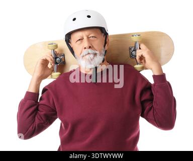 Homme senior dans le casque avec skateboard sur fond blanc Banque D'Images