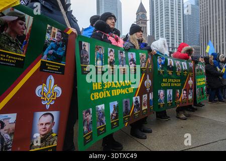 Toronto, ON, Canada – 22 février 2026 : des gens tenant des banderoles avec des portraits de soldats ukrainiens tombés au combat et des symboles ukrainiens, protestant pleinement Banque D'Images
