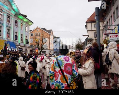 Langenthal, Berne, Suisse. 21 février 2026. Carnaval de Fasnacht dans la ville. Les participants au carnaval en costumes se rassemblent dans une rue avec un bu historique Banque D'Images