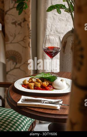 Burrata avec poulet rôti et vin rouge Banque D'Images