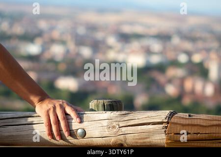 Gros plan de la main féminine reposant sur la balustrade en bois Banque D'Images