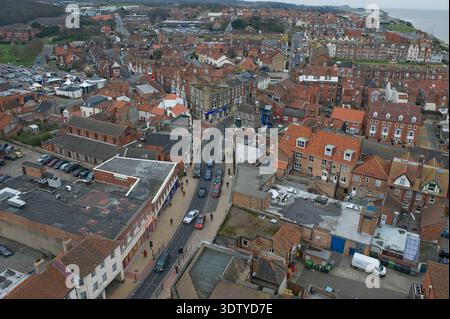 Une vue aérienne de la ville côtière de Cromer, Norfolk, située sur la côte de la mer du Nord. La perspective met en évidence l'architecture victorienne, l'église Saint-Pierre et Saint-Paul du XIVe siècle avec sa tour de 160 pieds, et la jetée classée Grade II, qui a ouvert ses portes en 1901. Historiquement un petit village de pêcheurs connu pour son 'crabe Cromer', la ville s'est développée en une station balnéaire populaire à la fin du XIXe siècle après l'arrivée du Great Eastern Railway. La vue englobe le paysage de falaise, les plages de sable et la disposition dense du centre-ville historique. Banque D'Images