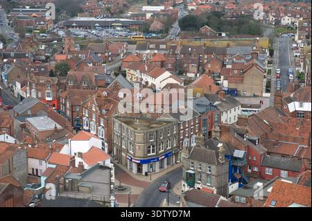 Une vue aérienne de la ville côtière de Cromer, Norfolk, située sur la côte de la mer du Nord. La perspective met en évidence l'architecture victorienne, l'église Saint-Pierre et Saint-Paul du XIVe siècle avec sa tour de 160 pieds, et la jetée classée Grade II, qui a ouvert ses portes en 1901. Historiquement un petit village de pêcheurs connu pour son 'crabe Cromer', la ville s'est développée en une station balnéaire populaire à la fin du XIXe siècle après l'arrivée du Great Eastern Railway. La vue englobe le paysage de falaise, les plages de sable et la disposition dense du centre-ville historique. Banque D'Images