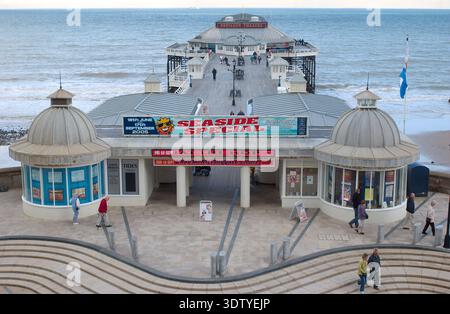 Une vue aérienne de la ville côtière de Cromer, Norfolk, située sur la côte de la mer du Nord. La perspective met en évidence l'architecture victorienne, l'église Saint-Pierre et Saint-Paul du XIVe siècle avec sa tour de 160 pieds, et la jetée classée Grade II, qui a ouvert ses portes en 1901. Historiquement un petit village de pêcheurs connu pour son 'crabe Cromer', la ville s'est développée en une station balnéaire populaire à la fin du XIXe siècle après l'arrivée du Great Eastern Railway. La vue englobe le paysage de falaise, les plages de sable et la disposition dense du centre-ville historique. Banque D'Images