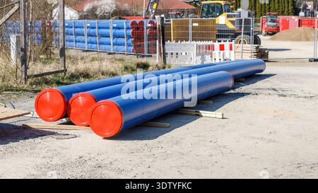 Pile de tuyaux bleus de l'infrastructure civile pour l'approvisionnement en eau, les égouts sanitaires. Pose de services publics souterrains sur la rue le long de la route. Réparation Banque D'Images