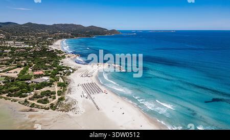 Superbe photo panoramique en angle levé mettant en valeur les eaux turquoises cristallines, le sable fin et blanc et les stations balnéaires le long de la côte de Villasimius. Banque D'Images