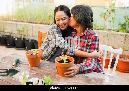 Mère asiatique et fille s'amuser ensemble tout en faisant du jardinage à la terrasse de la maison - style de vie familial, jour de maman, amour et concept de printemps Banque D'Images