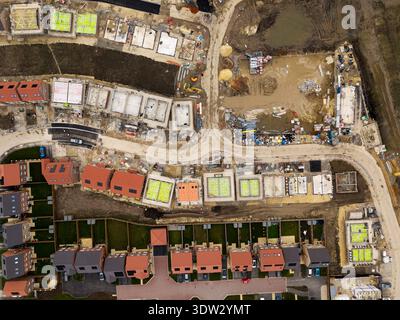 Vue aérienne de haut en bas au-dessus d'un chantier de construction construisant de nouvelles maisons écologiques abordables avec des panneaux solaires au Royaume-Uni sur des terres de ceinture verte Banque D'Images