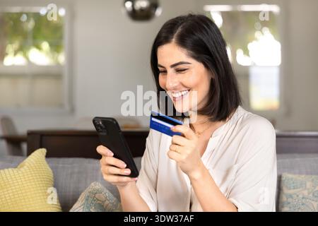 Heureuse belle jeune femme cliente hispanique magasinant de la maison Banque D'Images