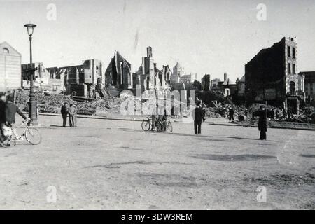 Civils dans la ville dévastée de Lisieux après le raid aérien allié du 6 juin 1944. Le 6 juin 1944, une énorme force d'invasion Alllied impliquant 7000 navires et 140 000 hommes débarque avec succès sur les côtes françaises et établit cinq têtes de plage. Une campagne de tromperie réussie signifiait qu'une grande partie de la résistance allemande était à Calais et que les pertes étaient relativement peu nombreuses compte tenu de l'ampleur et des dangers de l'opération. De nombreuses villes françaises historiques ont été détruites avant et pendant les débarquements. Banque D'Images