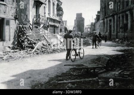 Civils dans la ville dévastée de Lisieux après le raid aérien allié du 6 juin 1944. n le 6 juin 1944, une énorme force d'invasion Alllied impliquant 7000 navires et 140 000 hommes débarque avec succès sur les côtes françaises et établit cinq têtes de plage. Une campagne de tromperie réussie signifiait qu'une grande partie de la résistance allemande était à Calais et que les pertes étaient relativement peu nombreuses compte tenu de l'ampleur et des dangers de l'opération. De nombreuses villes françaises historiques ont été détruites avant et pendant les débarquements. Banque D'Images
