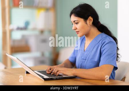 Médecin féminin travaille sur ordinateur portable dans la chambre Banque D'Images
