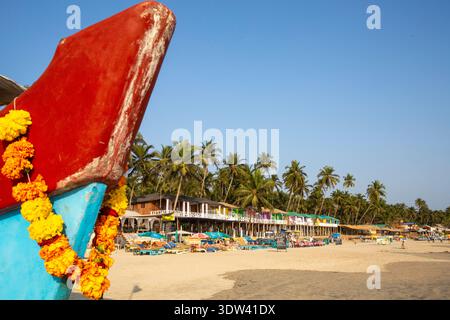 Scène de plage dynamique à Goa, en Inde, avec des cabanes colorées et des palmiers. Banque D'Images