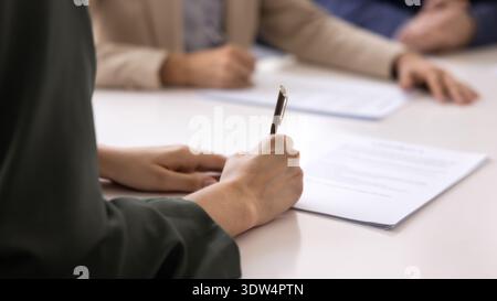 Gros plan d'une femme signant un contrat lors d'une réunion formelle Banque D'Images