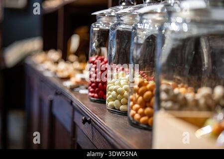 Bocaux en verre avec des bonbons, des noix glacées sur un présentoir Banque D'Images