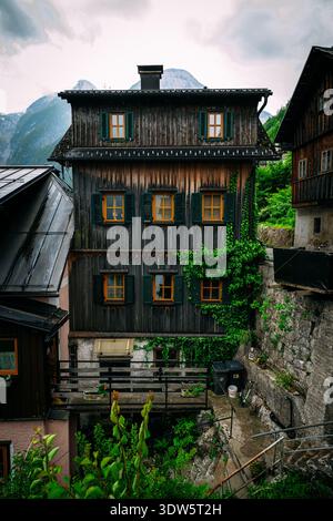 Charmante maison en bois aux volets verts nichée sur fond de montagne Banque D'Images