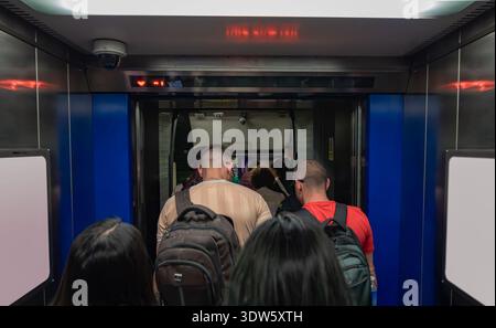 Londres, Royaume-Uni, 12 juillet 2023, les passagers sortent d'un train de métro à une station de métro. Les gens portent des sacs à dos en sortant Banque D'Images