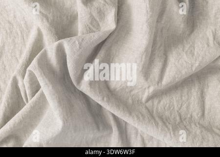 Tissu de lin naturel de couleur gris clair froissé comme fond avec espace de copie Banque D'Images