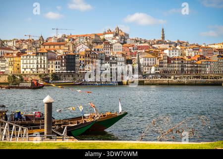 La vieille ville historique de Porto vue depuis le fleuve Douro, avec des bateaux rabelo traditionnels flottant le long du front de mer. Banque D'Images
