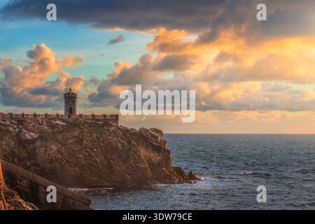 Vue panoramique du phare historique sur la Piazza Bovio au coucher du soleil. Ciel spectaculaire et falaise rocheuse surplombant la mer à Piombino, Toscane, Italie Banque D'Images