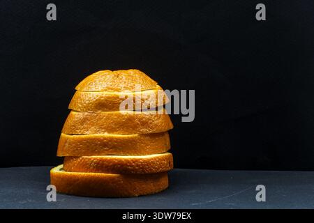 Style culinaire minimaliste créatif avec des tranches d'orange superposées avec un contraste fort et un espace négatif pour le placement du texte. Banque D'Images