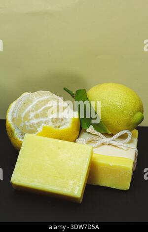 Gros plan du savon artisanal jaune et de la tranche de citron mettant en valeur les ingrédients naturels, les soins de la peau rafraîchissants et les produits durables faits à la main. Banque D'Images