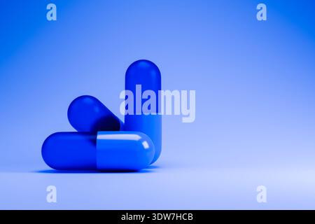 Capsules médicales bleues et blanches sur fond bleu Banque D'Images