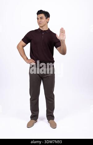 Portrait en longueur d'homme en polo marron et pantalon beige Banque D'Images