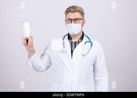 Docteur en manteau blanc tenant bouteille de pilules de médicament Banque D'Images