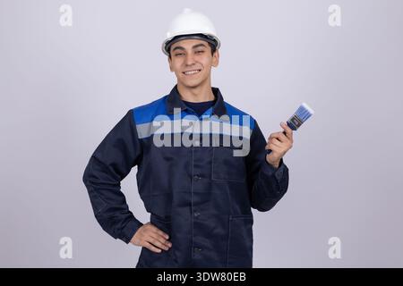 Technicien en uniforme de travail tenant des outils électriques dans le studio Banque D'Images