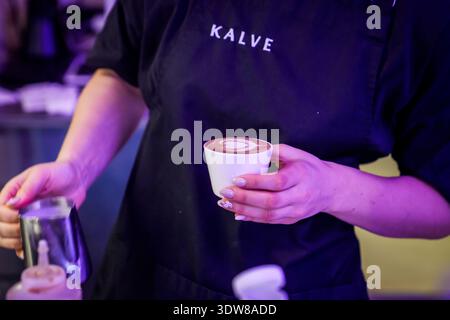 RIGA, LETTONIE. 24 février 2026. Un barista de Kalve Coffee Roastery verse habilement du lait vapeur pour créer un latte en forme de cœur Le café est moderne i Banque D'Images