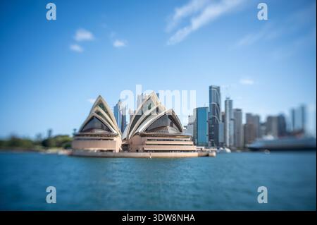 Artistique Lensbaby vue sélective sur l'Opéra de Sydney et les gratte-ciel de la ville sur le port. Banque D'Images