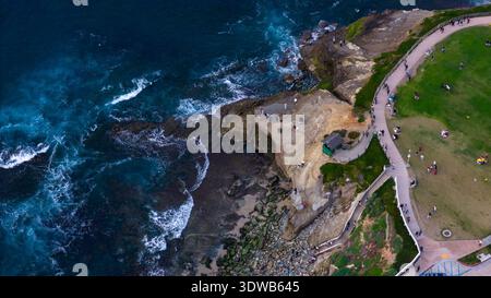 Vue aérienne de la côte accidentée où les falaises rencontrent l'océan, offrant un contraste spectaculaire avec le parc verdoyant de San Diego, Californie, Banque D'Images