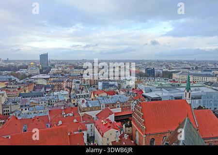 Vue panoramique sur les toits de la vieille ville et les bâtiments modernes au loin lors d'une journée couverte à Riga, Lettonie Banque D'Images