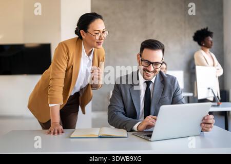 Portrait de gens d'affaires réussis travaillant, parlant ensemble dans le bureau de l'entreprise pendant le travail. Banque D'Images