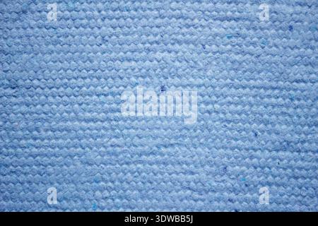 Un fond en papier bleu texturé fait à la main fabriqué à partir de matériaux recyclés, offrant un design unique et respectueux de l'environnement. La surface montre des fibres complexes Banque D'Images