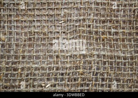 Un gros plan d'un tissu de lin grossier avec un grand tissage de toile, mettant en valeur sa texture naturelle et son charme rustique. Le tissage épais et organique Banque D'Images