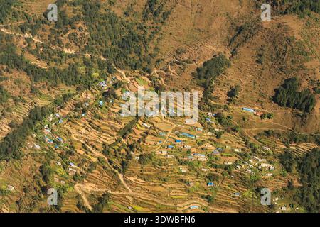 Vue par la fenêtre sur le vol de Lukla retour à Katmandou sur un village de montagne isolé, maisons traditionnelles entre les rizières en terrasses, Mount Everest base Camp Trek, EBC, Népal 2022 Banque D'Images