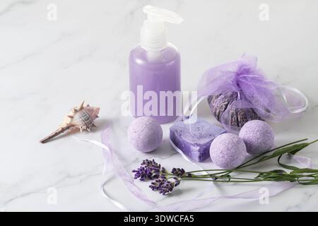 Ensemble d'aromathérapie avec fleurs de lavande pour la relaxation du bain et les soins du corps. Bouteille de shampooing, savon arôme et bombes à l'extrait de lavande, sachet séché fl Banque D'Images