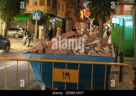Conteneur de débris de construction sur City Street la nuit Banque D'Images