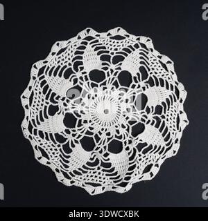 un crochet doily sur un fond noir Banque D'Images