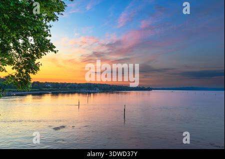 Un lever de soleil serein sur le lac de Constance (Bodensee). L'eau calme reflète les couleurs vibrantes du ciel, passant du rose et violet à l'orange A. Banque D'Images
