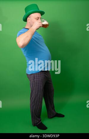 Homme dans le chapeau de leprechaun vert griller avec tasse de bière mousseuse.  : Patricks Day fête irlandaise. Tradition festive et concept de pub. photographie Banque D'Images
